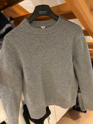 Grå stickad tröja (Arket, S) - Mysig grå stickad tröja med rund halsringning och ribbade muddar vid ärmslut och nederkant. Från Arket