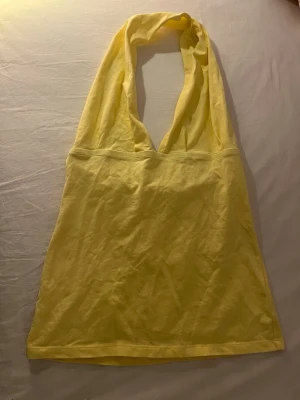 Gul halterneck topp - Super fin halterneck topp. Står L på lappen men känns mer som en m, strechight tyg. Pris kan absolut diskuteras.