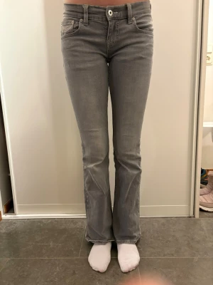 Grå bootcut jeans med broderade fickor - Snygga grå jeans från Gina Tricot strl 36 med bootcut passform och broderade detaljer på bakfickorna. Jeansen har klassisk femficksdesign, normal midja och är tillverkade i mjukt bomullsmaterial med stretch. 