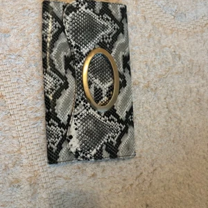 Kuvertväska i ormskinnsmönster - Väska med orm mönster på. (Vet inte märket) ⚠️ Ingen kedja eller axelband medföljer väskan.  Jag finns tillgänglig i Skövde, Borås & Värnamo om ni vill mötas istället för att betala frakt🙈❤️🥰