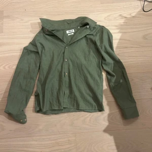 Grön skjorta från Solid - Snygg grön skjorta från Solid i regular fit. Skjortan har klassisk krage, knäppning framtill och långa ärmar med manschett och knappar. Perfekt för en clean och avslappnad look. Den är även nästan helt oanvänd, har använt den på en student och den är skit skön men har andra skjortor jag använder mer så har inte behov av den.