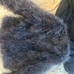 Grå pälsjacka från WOS - Säljer en fluffig och riktigt snygg grå pälsjacka från WOS.Passar perfekt till höst och vinter!