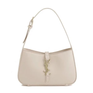 Beige axelväska  - Snygg beige axelväska  med ikoniskt YSL-emblem i guld framtill. Väskan har stilren design, justerbart axelband och är tillverkad i slätt skinn. Perfekt för dig som vill ha en lyxig och trendig accessoar.