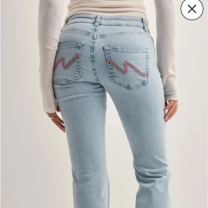 Ljusblåa jeans Nelly  - Säljer ett par ljusblå jeans från Nelly i storlek 36 med rosa detaljer och hål i knäna. Jättefina, använda men fortfarande i bra skick har blivit lite förstörda nere vid hälen för dom har släpats lite i marken. Hör av er om bild på de och pris kan diskuteras. 🩷