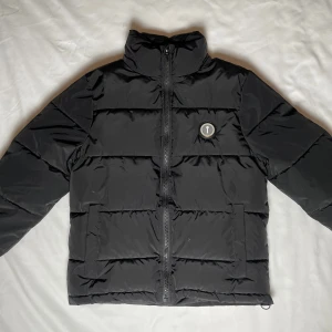 Svart trapstar jacka - Säljer en väldigt ny trapstar jacka då jackan har används några fåtals gånger men annars fantastiskt skick, jackan har ej några hål eller synliga fläckar. Kom gärna privat för mer information eller bilder på jackan😊priset kan alltid förhandlas vid snabb affär!