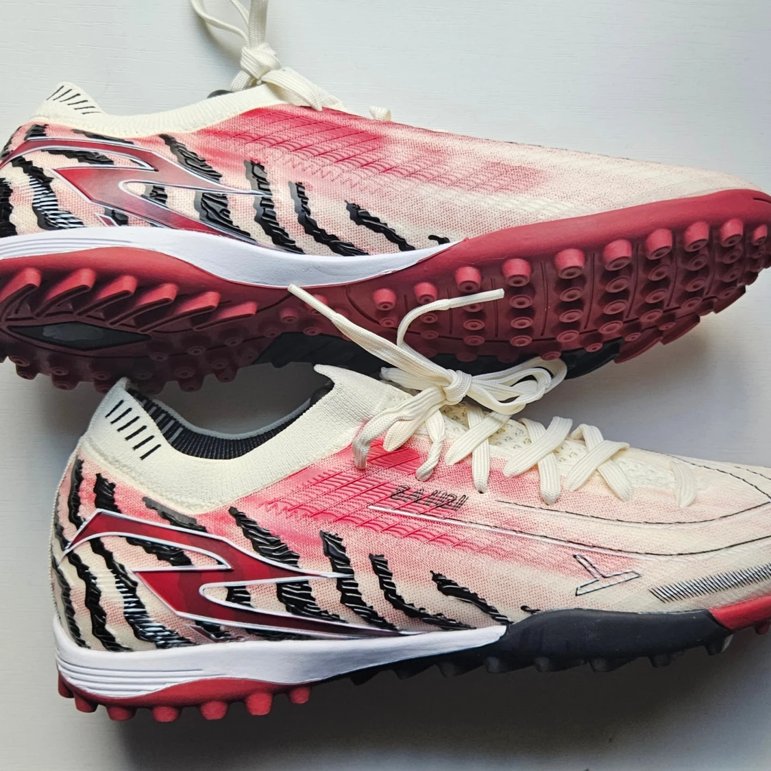 Zebramönstrade fotbollsskor i rött och vitt