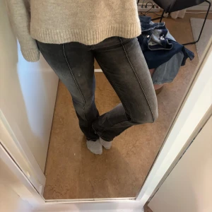 Bootcut jeans från Bershka - Säljer ett par grå jeans från Bershka i bootcut-modell. Jeansen har en snygg tvättad look och klassisk femficksdesign. Materialet är jeans och passformen är normal med lätt utsvängda ben. Perfekta för dig som gillar en avslappnad men trendig stil.