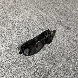 Svarta Ray-Ban solglasögon - Säljer ett par svarta Ray-Ban Justin RB4165 solglasögon med mattsvart båge och mörka linser. Klassisk och stilren modell🤩 glasögonen är i fint skick har några få repor men annars väldigt fina✅ Nypris:1000kr mitt pris:399kr priset är självklart inte hugget i sten🪨 och det är bara att skriva vid några funderingar💯