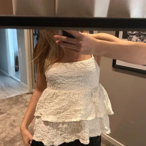 Vit volang topp - Supersöt vit linnetopp med smala axelband och smockad struktur. Från Gina 