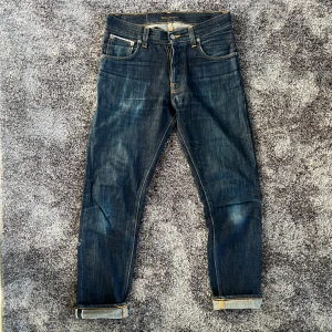 Nudie Jeans Selvedge - Säljer dessa sjuka selvedge jeans från Nudie Jeans, modell Steady Eddie l. Tillverkade i 100% ekologisk bomull. Använda i 3 månader med en tvätt. Har ett litet hål i höger ficka.  Nypris: 3000kr. W: 42 cm tvärs över L: 77 (innerben) Hör av er vid frågor !