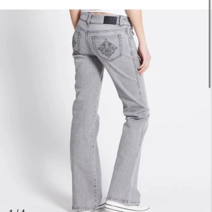 Grå bootcut jeans med broderi - Snygga grå jeans med bootcut passform och broderade detaljer på bakfickorna. Jeansen har låg midja, klassisk femficksdesign och är tillverkade i mjukt denimtyg. Perfekta för dig som vill ha en chill och trendig look.❤️