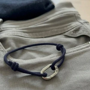 Armband navy - Marininspirerat armband – Stil & Kvalitet från Armory  Upptäck det perfekta komplementet till din stil! Detta marinblå armband med en detalj kombinerar en elegant design med en avslappnad, nautisk känsla. Ett utmärkt val för dig som vill ha en diskret men stilfull accessoar eller en uppskattad present till någon speciell.  Hör av dig vid frågor/ armory
