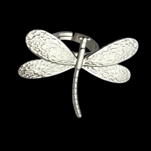 Silverfärgad ring med trollslända - Unik ring i silverfärg med en stor trollslända som motiv. Vingarna har ett snyggt texturerat mönster som ger extra detalj och cool känsla. Perfekt statement piece för dig som gillar naturinspirerade accessoarer.