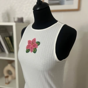 Pärlbroderad klänning  - Jag säljer denna fina klänning som jag pärlbroderat en blomma på 