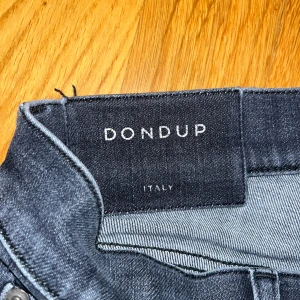 Mörkblå skinny jeans från Dondup - Snygga mörkblå jeans från Dondup med klassisk femficksdesign och diskreta slitningar framtill. Jeansen har smal passform och är tillverkade i stretchigt denim för extra komfort. Perfekt för dig som gillar en modern och stilren look.