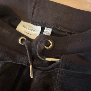Svarta velourbyxor Juicy Couture - Svarta mjukisbyxor från Juicy Couture i mjuk velour med mer åt bootcut hållet. Byxorna har fickor både fram och bak med knappstängning, samt elastisk midja för skön passform. Användna några gånger men är för korta för mig som är 1,58 cm lång. Det går att diskutera priset!☺️