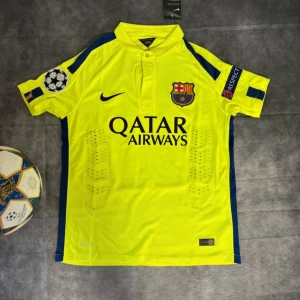 FC Barcelona Neymar JR 11 Champions League tröja - Säljer en FC Barcelona bortatröja från Nike med Neymar JR 11 på ryggen. Tröjan är gul med mörkblå detaljer, Champions League och Respect-patchar på ärmarna samt klubbmärke och Qatar Airways-tryck på bröstet. Tillverkad i lätt och ventilerande polyester.