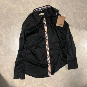 Svart Burberry skjorta  - Helt ny Svart skjorta från Burberry i storlek S. Hör gärna av er om ni undrar något eller har några frågor!