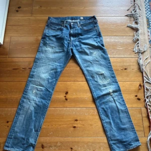Levi's 505 Japan blå jeans W33 L34 - Säljer ett par Levi's 505 jeans, tillverkade i Japan. De är blå med slitningar och har klassisk femficksdesign. Jeansen har rak passform och är gjorda i robust denim. Perfekt för dig som gillar vintage och streetwear.