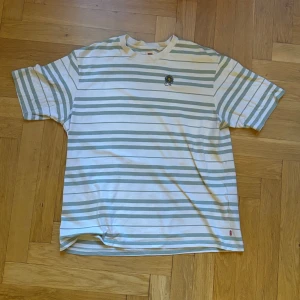 Randig oversized t-shirt från Levi's - Säljer en oversized t-shirt från Levi's i storlek M. Sällan använd och har en riktigt schysst brodyr på bröstet.