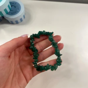 Kristall armband - Ett snyggt armband med gröna, oregelbundna kristaller som sitter på en elastisk tråd. Kristallerna är aventurin. Aldrig använd och har Inge defekter, som ny. Stretchigt band. Köpt på regnbågens böcker och smycken i Haga Göteborg. 