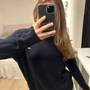 Stickad tröja marinblå  - Snygg mörkblå stickad tröja från GANT med liten broderad logga på bröstet. Storlek L men sitter mer som S. Supersjuk och jätteskön. Inga tecken på användning.