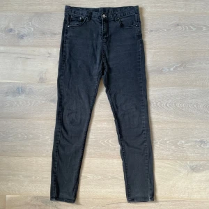Svarta skinny jeans med hög midja - Svarta jeans i mycket gott skick, utan slitningar eller fläckar. Tyget har bra elasticitet och består av 100 % bomull. Midja: 76 cm, längd: 98 cm. Säljes eftersom storleken inte passar längre.
 Tillgänglig för upphämtning i Kista, Stockholm, eller leverans.
 
