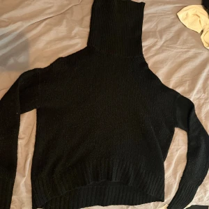 Svart polotröja från 157, storlek S - Svart ribbstickad polotröja från 157 i storlek S. Tröjan har lång ärm, hög polokrage och är gjord i ett mjukt stickat material som känns skönt mot huden. Perfekt för en clean, enkel look.