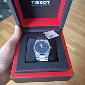 Swiss klocka - En väldigt fin klocka med silverband och blå urtavla. Klockan är helt ny och aldrig använd. Vid snabb affär kan priset eventuellt diskuteras