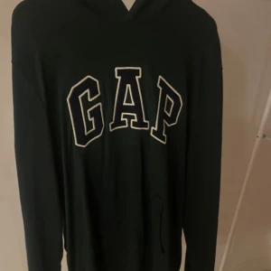 GAP hoodie - Mörkgrön hoodie från GAP i lite tunnare tyg. Använd nån gång med i väldigt bra skick! Skriv för fler bilder
