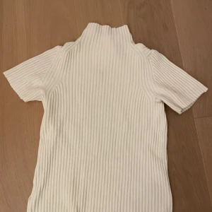 Vit ribbad polotopp med kort ärm - Säljer denna supersöta vita stickade & ribbade tröjan med krage från COS. Inga defekter!! 🩷