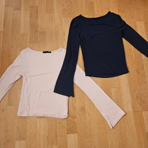 Två långärmade toppar i rosa och blå. - Säljer två stilrena långärmade toppar i storlek 146-152, i ljusrosa och en i mörkblå. Båda har en enkel, rak passform och rundad halsringning. Perfekta att matcha med jeans eller kjol för en clean look. Materialet känns mjukt och stretchigt, troligen bomull eller polyester.