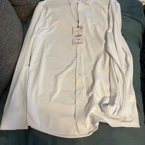 Vit skjorta från Zara i storlek L - Säljer en klassisk vit skjorta från Zara i storlek L. Skjortan har lång ärm, knappar framtill och en stilren krage. Perfekt för dig som gillar en clean och enkel look. Materialet är mjukt och känns skönt mot huden.