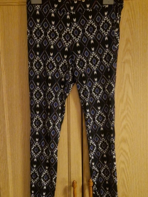 Mönstrade leggings från Divided, S - Säljer ett par svarta leggings från Divided i storlek S med ett geometriskt mönster i vitt och blått. De är tighta och har elastisk midja för skön passform. Perfekta för dig som gillar att sticka ut med coola printsen. Kolla gärna in mina andra annonser! 