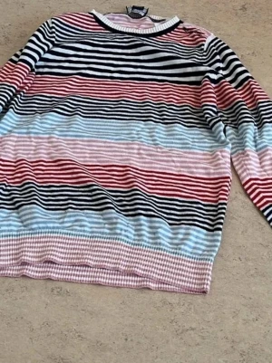 Randig stickad tröja  - Jag säljer en randig tröja i mycket bra skick! Tröjan har ett klassiskt randigt mönster i marinblått och vitt, vilket gör den lätt att matcha till det mesta. Den är tillverkad i mjuk och skön bomull, perfekt för både vardag och helg. Tröjan är i storlek M och har en normal passform. Den är sparsamt använd och i utmärkt skick – inga fläckar, hål eller andra defekter.  Perfekt för dig som vill ha en snygg och bekväm tröja till ett bra pris. Kontakta mig om du är ontresserad eller har några frågor!