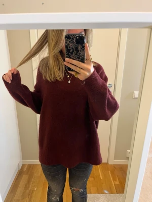 Vinröd stickad tröja från Stradivarius - Mysig vinröd stickad tröja från Stradivarius i oversized modell. Tröjan har rund hals, långa ärmar och är tillverkad i ett mjukt material som passar perfekt för kyliga dagar. Enkel design utan mönster eller detaljer, vilket gör den lätt att matcha med jeans eller andra plagg.💖