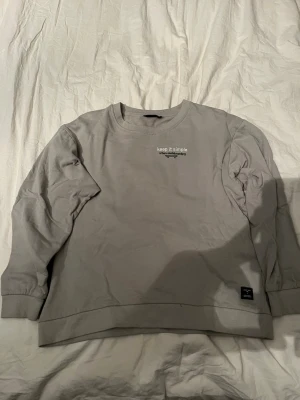 Grå sweatshirt från 157 med tryck - Grå sweatshirt från 157 med trycket 'keep it simple urban.skateboarding' på bröstet och större tryck på ryggen. Tröjan har rund hals, långa ärmar och är gjord i mjuk bomull. Perfekt för en chill streetwear-look.