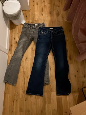 Gina Tricot Young Bootcut Jeans - Säljer två par bootcut jeans från Gina Tricot, ett par i grå tvätt och ett par i mörkblå denim. Båda är lågmidjade och har snygga ficklock bak med knapp💞 Båda i storlek 158 - Young. 200kr för båda eftersom att jag flyttar och måste bli av med grejer!