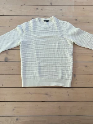 Vit tröja från J.Lindeberg - Sjukt fin j.Lindberg sweatshirt i storlek M som även passar dig som har storleken S.  Stilren J.Lindeberg-tröja –  J.Lindeberg – våffelstickad struktur som ger ett exklusivt, uttryck och samtidigt känns mjuk och bekväm mot kroppen – lika snygg till vardags som till en mer uppklädd look.  ✔ Original J.Lindeberg ✔ Storlek: M ✔ Modern, tidlös design ✔ Bekväm och följsam passform ✔ Perfekt för lager-på-lager eller att bära som den är Missa inte chansen att lägga vantarna på denna fina tröja,  Mvh