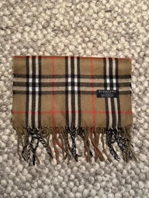 Rutig halsduk från Burberry i ull - Säljer en riktigt snygg Burbbery halsduk. Skriv gärna om ni har extra frågor 😁Priset kan absolut diskuteras 🙌