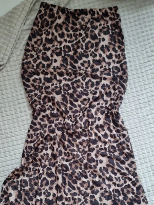 Långkjol med leopardmönster - Säljer en långkjol med coolt leopardmönster i beige och svart. Kjolen har en smickrande, figurnära passform och är tillverkad i ett mjukt och lätt material som känns skönt mot huden. Perfekt för dig som vill sticka ut med en trendig look. Passar perfekt för stranden eller liknande 