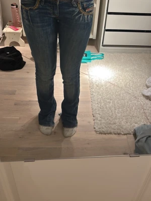 Blå bootcut jeans med broderade fickor - As snygga vintage jeans från diesel. De är i bra skick men jag har sytt jeansen till bootcut längst ner vid benen så de är inte så bra sydda och är lite sönder. Säljer eftersom de är för små💕