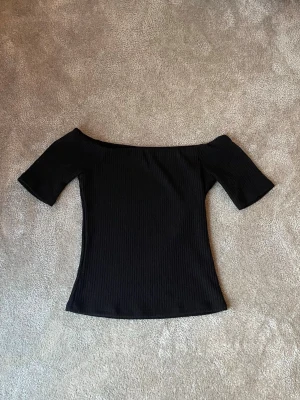 Svart ribbad offshoulder topp - Snygg svart ribbad offshoulder topp från HM💕