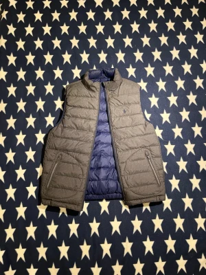 Vändbar väst från Polo Ralph Lauren - Tvåsidig väst från Raffe. Superbra skick och riktigt snygg. Storleken är L i ungdomsstorlek men passar som S eller XS i vanlig storlek. Skriv vid minsta fundering! 