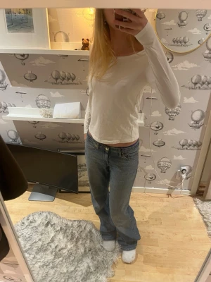 Vit långärmad topp - En enkel och stilren vit långärmad topp med rund halsringning. Modellen är normal i passningen men är lite thight i armarna. Det är lite fläckar på men inget som sysn tror jag.