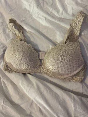  Intimissimi Gioia bh 75c - Viral push up bh från Intimismi. Snygg beige bh från Intimisssimi med spetsdetaljer och blommigt mönster. Bhn har justerbara axelband. 