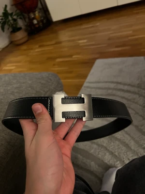 Svart H bälte - Säljer mitt bälte då jag inte gillade det så mycket. Använd fåtal gånger, 115cm