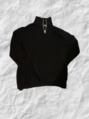 Svart half zip tröja Jack & Jones - Svart långärmad tröja från Jack & Jones i storlek S. Tröjan har en hög krage med half zip-dragkedja framtill och ribbade muddar vid ärmslut och nederkant. Perfekt för dig som gillar stilren och enkel design. Mvh Holmbergsresell