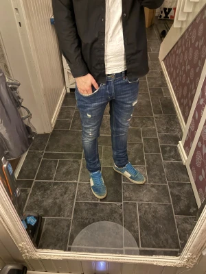 Dondup jean - Säljer ett par blå skinny jeans från Dondup i storlek W29. Jeansen har slitna detaljer och ljusa partier på låren för en trendig look. Klassisk femficksmodell med smal passform och normal midja. Perfekta för dig som gillar en modern och avslappnad stil.