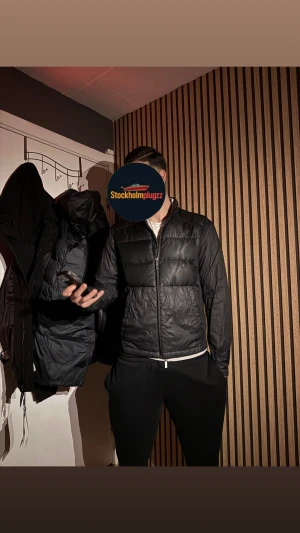 Svart jacka från Hugo Boss - Svart pufferjacka från Hugo Boss med avtagbara ärmar så den kan användas som väst.logotyp på ryggen. Helt ny aldrig använd skriv vid minsta fundering